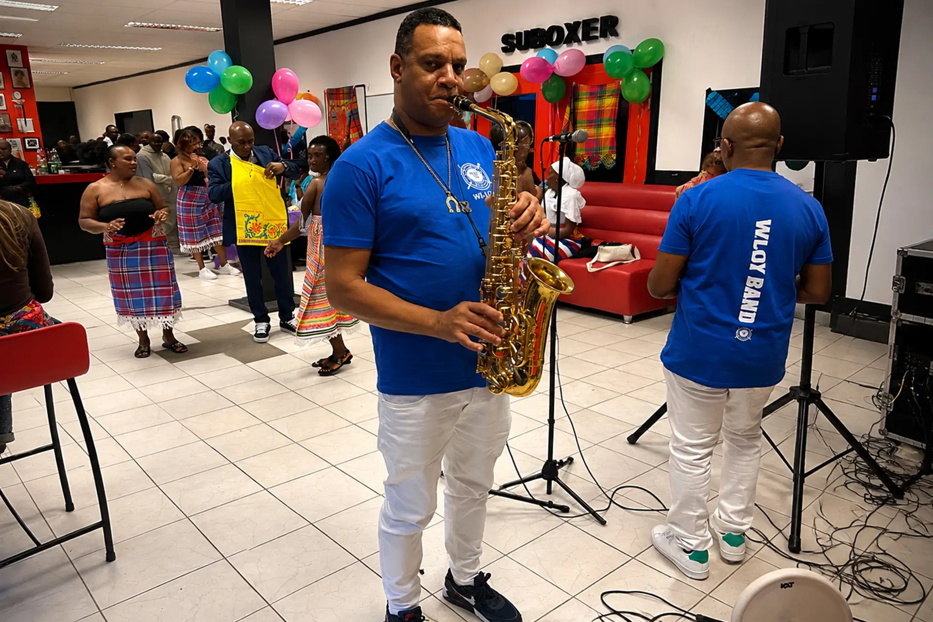 Zanger en muzikanten van We Lobi Band tijdens een feest